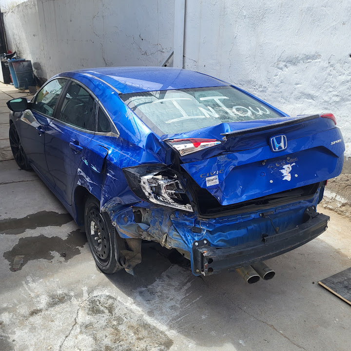 Civic azul con daños traseros al llegar al taller, antes de la reparación