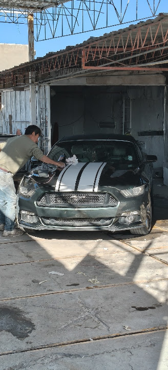 Limpieza manual del Mustang durante el detallado en el taller